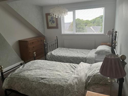 1 dormitorio con 2 camas individuales y ventana en Matlock Maisonette en Matlock