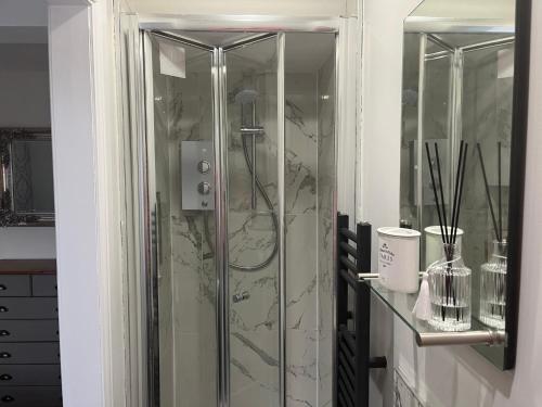 a shower with a glass door in a bathroom at Matlock Maisonette in Matlock