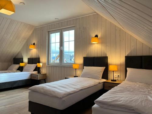 1 dormitorio con 2 camas y 2 lámparas y ventanas en Domek Relaks pod Śnieżką, en Miłków