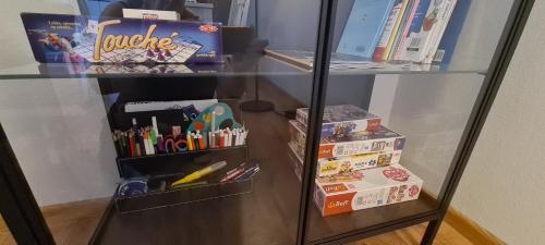 a glass shelf with some school items and books at Viscosa Holiday Apartment in Kõrgessaare