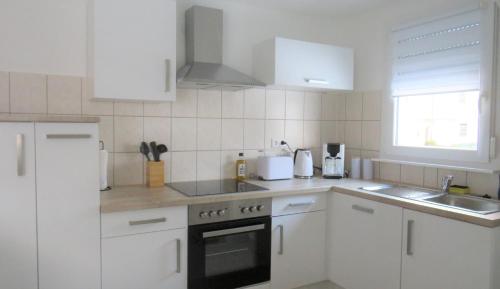 a kitchen with white cabinets and a stove top oven at Alte Schule, Ferien- und Monteurwohnung in Gernsbach