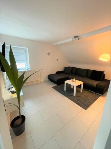 a living room with a black couch and a table at Alte Schule, Ferien- und Monteurwohnung in Gernsbach