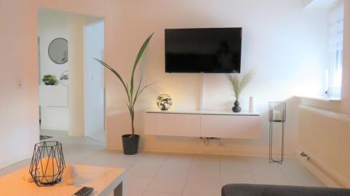 a living room with a tv on a wall at Alte Schule, Ferien- und Monteurwohnung in Gernsbach