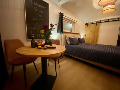 Cette chambre dispose d'une table, d'un lit, d'une table et d'une chaise. dans l'établissement Style Gardenhouse Zwanenburg near AMSTERDAM, HAARLEM, ZANDVOORT, à Zwanenburg