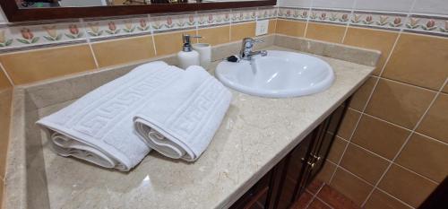 ein Badezimmer mit einem Waschbecken und Handtüchern auf der Theke in der Unterkunft Descubre el encanto del Tamaduste en tu refugio vacacional in Tamaduste