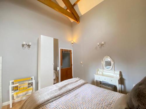 a bedroom with a bed and a mirror in it at Heronston Barn Cottage in Bridgend