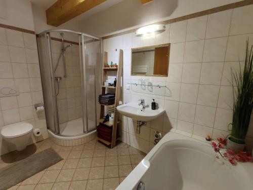 a bathroom with a tub and a sink and a toilet at Penthouse Aineckblick in Sankt Margarethen im Lungau