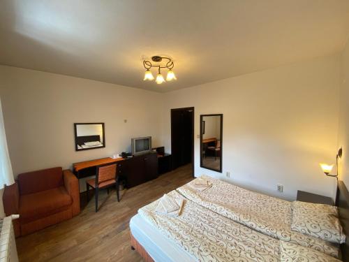 1 dormitorio con cama, escritorio y silla en House Trivia en Bansko