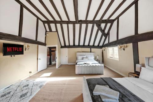 a bedroom with a large bed in a room at 6 Bed Countryside Mansion With Tennis Court & Swimming Pool with Parking in East Horsley
