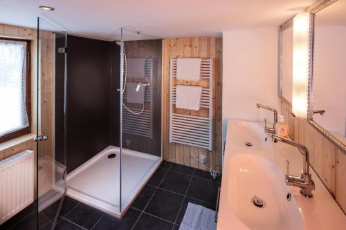 ein Bad mit einer Badewanne, einer Dusche und einem Waschbecken in der Unterkunft Alps Romantik in Mellau