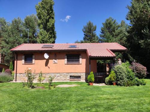 a house with a green yard in front of it at La Finca de Gredos in Hoyos del Espino