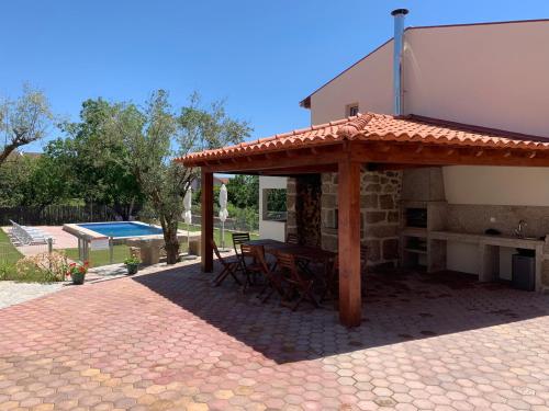 un pabellón con mesa y sillas junto a una casa en 6 bedroom countryhouse with pool - Casa do Sepião, en Vinhal