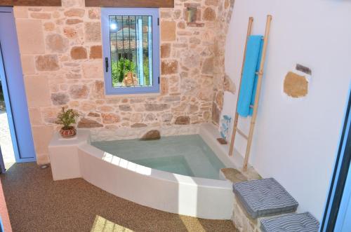 een bad in een kamer met een hond in een raam bij Mouse House with Sea View and Mini Pool in Plataniás