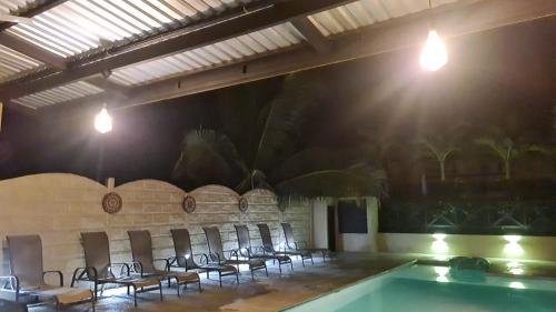 um quarto com cadeiras e uma piscina em Cabina Don Luis em San Juanillo