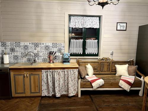 a kitchen with a wooden bench and a window at Drewniana chata nad stawem in Krasiczyn