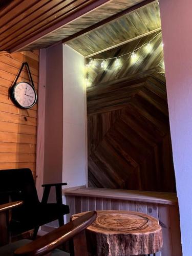 a room with a wooden door and a table and a clock at Drewniana chata nad stawem in Krasiczyn