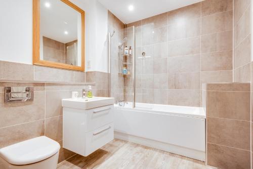 a bathroom with a toilet and a tub and a sink at Modern Spacious Bright 1-Bedroom Ground Floor Flat in Oxford