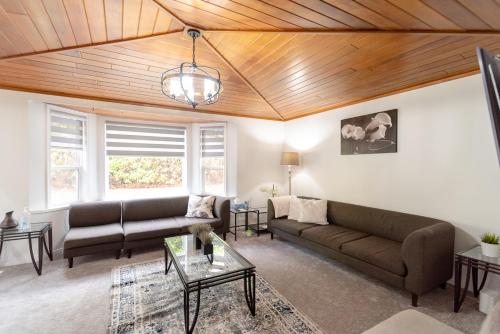 a living room with couches and a wooden ceiling at Spacious & Modern by the Beach in White Rock