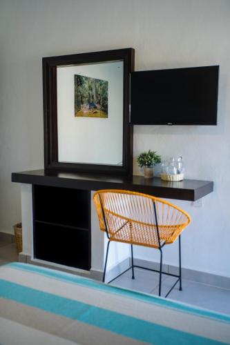 a mirror and a chair in a room at Hotel Camino Del Sol in Puerto Escondido