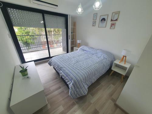 a bedroom with a bed and a large window at VM 1254 - Departamento APART - con Cochera in Rosario