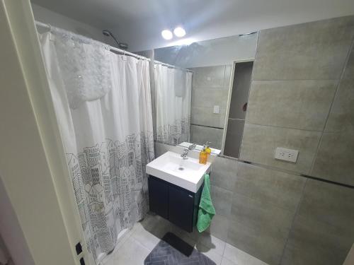 a bathroom with a sink and a shower curtain at VM 1254 - Departamento APART - con Cochera in Rosario