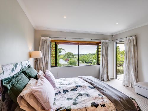 a bedroom with a large bed and a window at Busby Hill Villa - Havelock North Holiday Home in Havelock North
