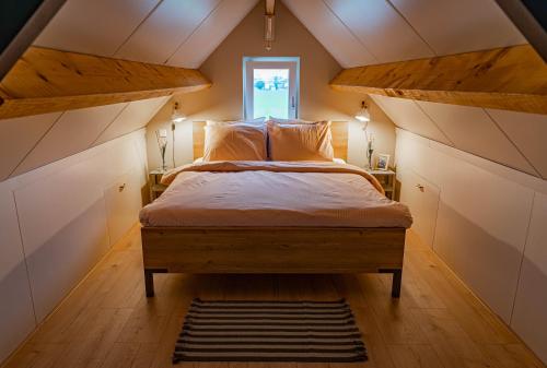 1 dormitorio con 1 cama grande en el ático en Gastenverblijf de Vense Weide, en Venlo