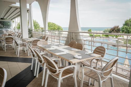 アルベナにあるLaguna Beach Hotelのテーブルと椅子が備わり、海の景色を望むレストラン