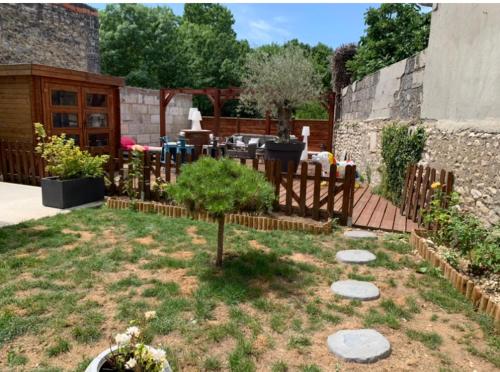 a garden with a table and a tree in the yard at Studio entier Tout confort in Le Gond-Pontouvre