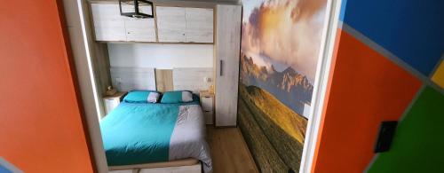 - une petite chambre avec un lit et un mur coloré dans l'établissement La Perle du Sancy, à La Bourboule