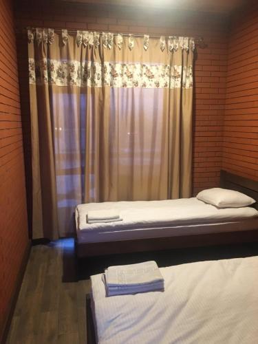 a bedroom with two beds and a curtain at Dvir Litynskyi in Lityn