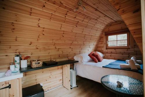 een slaapkamer met een bed in een houten hut bij River Side Cabin with Hot tub Snowdonia in Barmouth