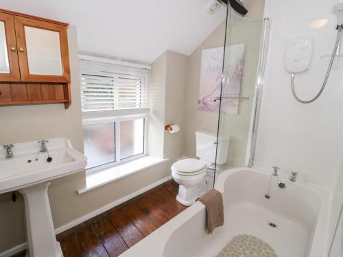 a bathroom with a tub and a toilet and a sink at Arwel in Capel Garmon