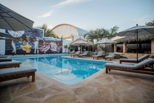 - une piscine avec des chaises et des parasols dans un complexe dans l'établissement Hotel Camino Del Sol, à Puerto Escondido