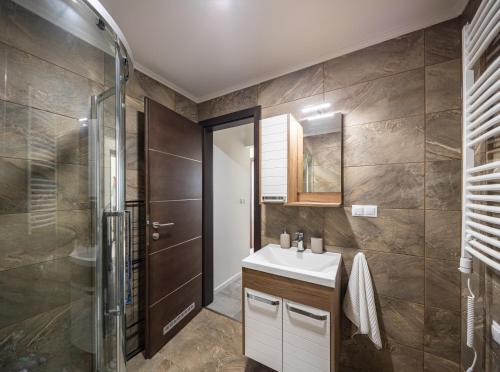 een badkamer met een wastafel en een douche bij Balatonic Panoráma in Zamárdi