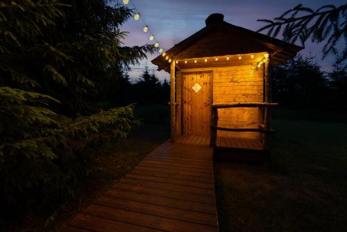 a wooden out house with lights on it at night at Kuusehaldja Glamping in Kohila