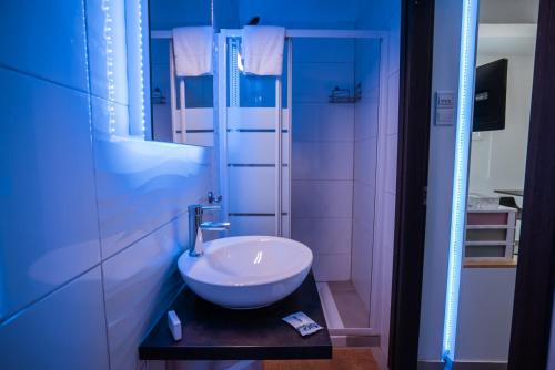 a bathroom with a white sink and a mirror at Tsolias Apartments in Protaras