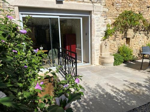 a door to a building with purple flowers at Coeur de Pommard in Pommard