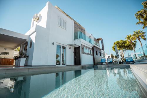 a house with a swimming pool next to a building at Tsolias Apartments in Protaras