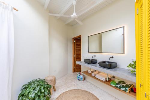 een badkamer met een wastafel en een spiegel bij Naïma Luxury Home, Cottage & Apartment Rentals in Paradera