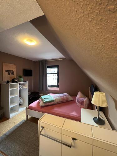 sypialnia z czerwonym łóżkiem na poddaszu w obiekcie Landhaus Bavaria w mieście Bad Nauheim