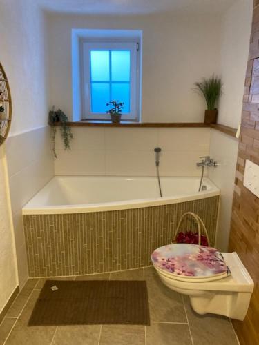 ein Badezimmer mit einer Badewanne und einer rosa Schale in der Unterkunft Urlaub auf der Alm "Deluxe" Matzlerberg in Lobming