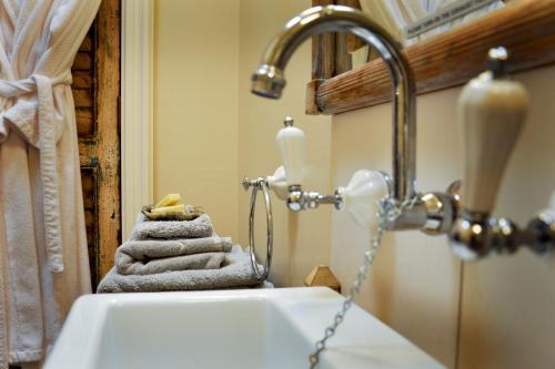 La salle de bains est pourvue d'un lavabo et d'un porte-serviettes. dans l'établissement Athelney Cottage Bed and Breakfast, à Adélaïde