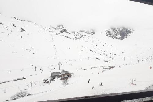 une piste de ski couverte de neige avec des personnes qui y skieront dans l'établissement Le Petit La Mongie, à Bagnères-de-Bigorre