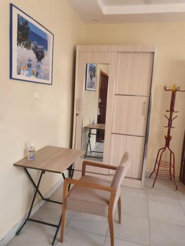Habitación con mesa, mesa y silla en Résidence Hadja 01, en Dakar