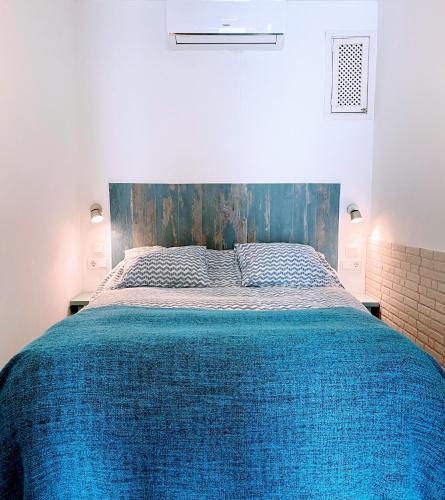 a bedroom with a large bed with a blue blanket at La Casa de Yiyi in San José