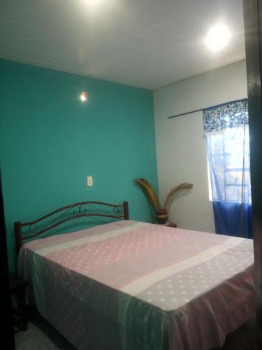 1 dormitorio con cama y pared azul en Grahl house, en Encarnación