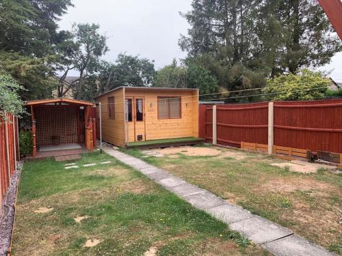 a small house in a yard next to a fence at Huntingdon walk to town centre, cosy, Free parking in Huntingdon