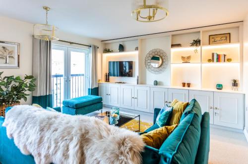 sala de estar con sofá azul y perro en Chic, immaculate, stylish Warwick apartment close to town & castle - perfect for short & long breaks, en Warwick