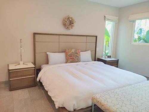a bedroom with a large white bed and a window at Elan at Ballena Beach in Uvita